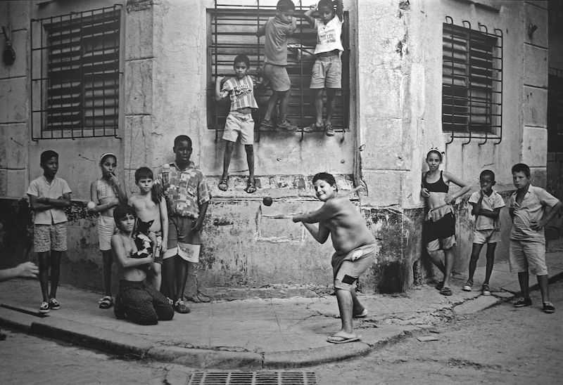 Kids playing stickball in Havana, 1999. By Cliff. Wikipedia/Flickr (CC BY 2.0) "There's a famous picture taken in the '50s of Willie Mays playing stick ball in Harlem. I played a lot of stick ball growing up and always loved it. I wanted to replicate the Mays photo in Cuba because baseball is the national sport there. It's everywhere. Cuban children play ball in the streets like kids in U.S. cities used to do. It was my last Saturday on this trip and I was slowly weaving through the streets of old Havana, looking for kids playing ball, when I came upon this corner, La Esquina. If you study the picture, you see that every eye, not just the kids' but even the dog's, is on that taped ball. It's the decisive moment, and there's no way to anticipate when you're going to get it. I had a vision of a picture that I'd tried and tried and tried to find but hadn't yet, and I came within a day of not finding it. To me it was all about getting the photograph I'd been searching for and I did it in 20 frames."