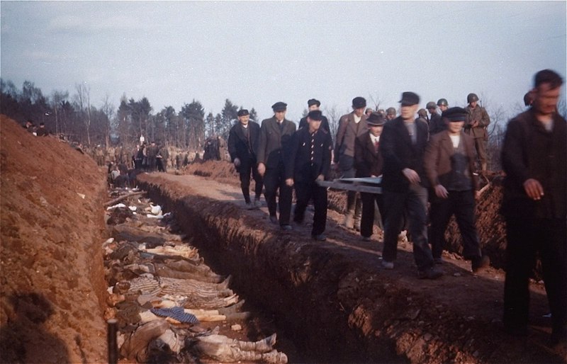 Supervised by American soldiers, German civilians from the town of Nordhausen bury the corpses of prisoners found at the Mittelbau-Dora concentration camp in mass graves. Rare colour photograph taken in 1945. (public domain)   